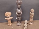 trois statues en bois de formes et de tailles différentes posées sur une table