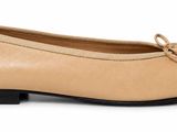 the woman is wearing a tan and black shoe with a bow on the side