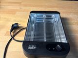 a black heater on a wooden table with a black background