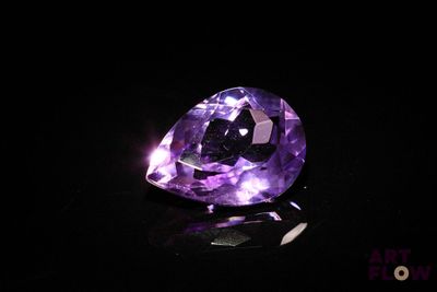 a close up of a purple diamond on a black surface