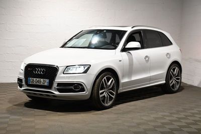 Le SUV Audi blanc est garé dans une pièce blanche