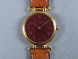 un gros plan d'une montre-bracelet au cadran rouge