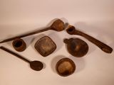 several wooden spoons, bowls and spoon rest on a white surface