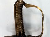 a gold colored sword on a white surface