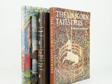 three books are stacked on top of each other on a white surface