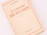 un livre posé sur une surface blanche, bordé d'un liseré rouge