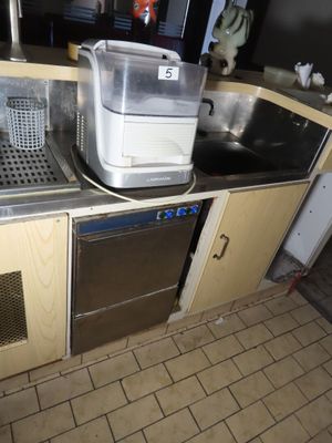 une cuisine équipée d'un évier, d'un lave-vaisselle et d'un grille-pain posé sur le plan de travail