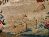 a chair that has a bird on it and flowers on the back