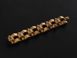 a close up of a gold bracelet on a black surface