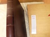 a brown book sitting on top of a table next to a pair of scissors