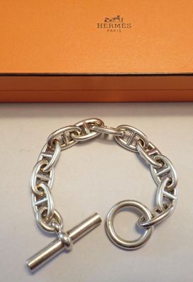 une boîte orange contenant un bracelet à chaîne en argent et un fermoir en argent