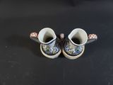 two cups that are sitting on a black table