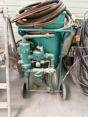 a green cart with a bunch of hoses on top of it