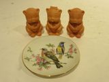 three small ceramic bears and a plate with a bird on it
