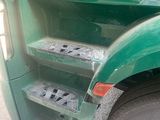 a green truck with steps on the side of it