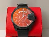 a black and orange watch sitting on a red box