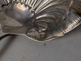 a silver plate with a spoon on it on a table
