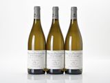 three bottles of white wine sitting next to each other on a white surface