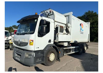 un camion-poubelle blanc garé sur un parking