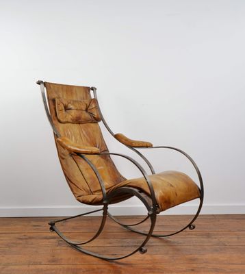 an old rocking chair in a room with wood floors and a white wall