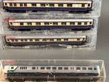 four train cars in a display case on a table
