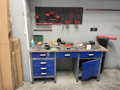 a workbench in a garage with many tools on it