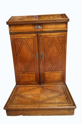 an old wooden cabinet with two doors and a drawer on top of it
