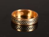 a close up of a gold ring on a black surface