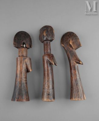three wooden figurines of a man and a woman