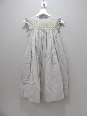 a white dress hanging on a hanger against a wall
