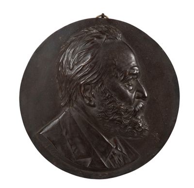 un gros plan sur un médaillon en bronze représentant le visage d'un homme