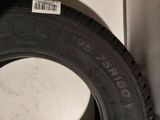 tire of a car with a sticker on it sitting next to a wall