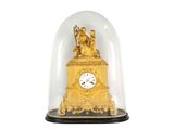 une horloge dorée sous un dôme en verre, sur fond blanc