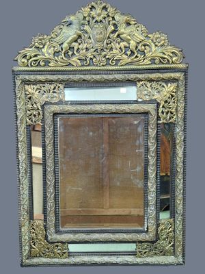 an ornately carved mirror with a gold frame on a gray background