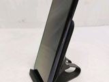a close up of a cell phone on a stand on a white surface