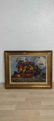 une photo d'un tableau accroché au mur à côté d'un vase