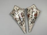 une paire de vases décoratifs ornés de motifs floraux, posés sur une table