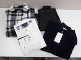 three men ' s shirts and pants are laid out on a table