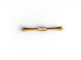 a gold plated metal pin with a small diamond on it