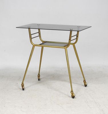a gold metal and glass side table with a glass top