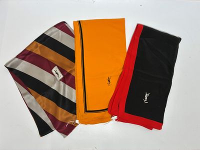 trois écharpes de couleurs différentes posées sur une surface blanche