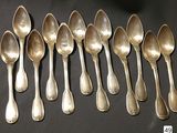 six silver spoons are lined up on a black surface