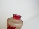 un vase en verre orné d'une fleur rouge
