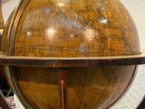 a large wooden globe on a stand in a room