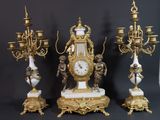 three antique clocks are sitting next to each other on a table