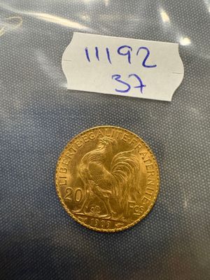 a close up of a gold coin with a sticker on it