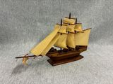 a wooden model of a sailing ship on a stand