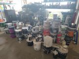 many cans of paint sitting on the floor in the garage