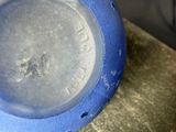 a close up of a blue vase on a table