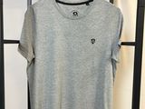 un t-shirt gris suspendu à un portant dans une pièce